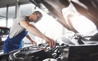 Picture showing muscular car service worker repairing vehicle