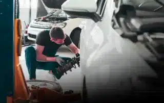 European car mechanic inspecting vehicle underbody