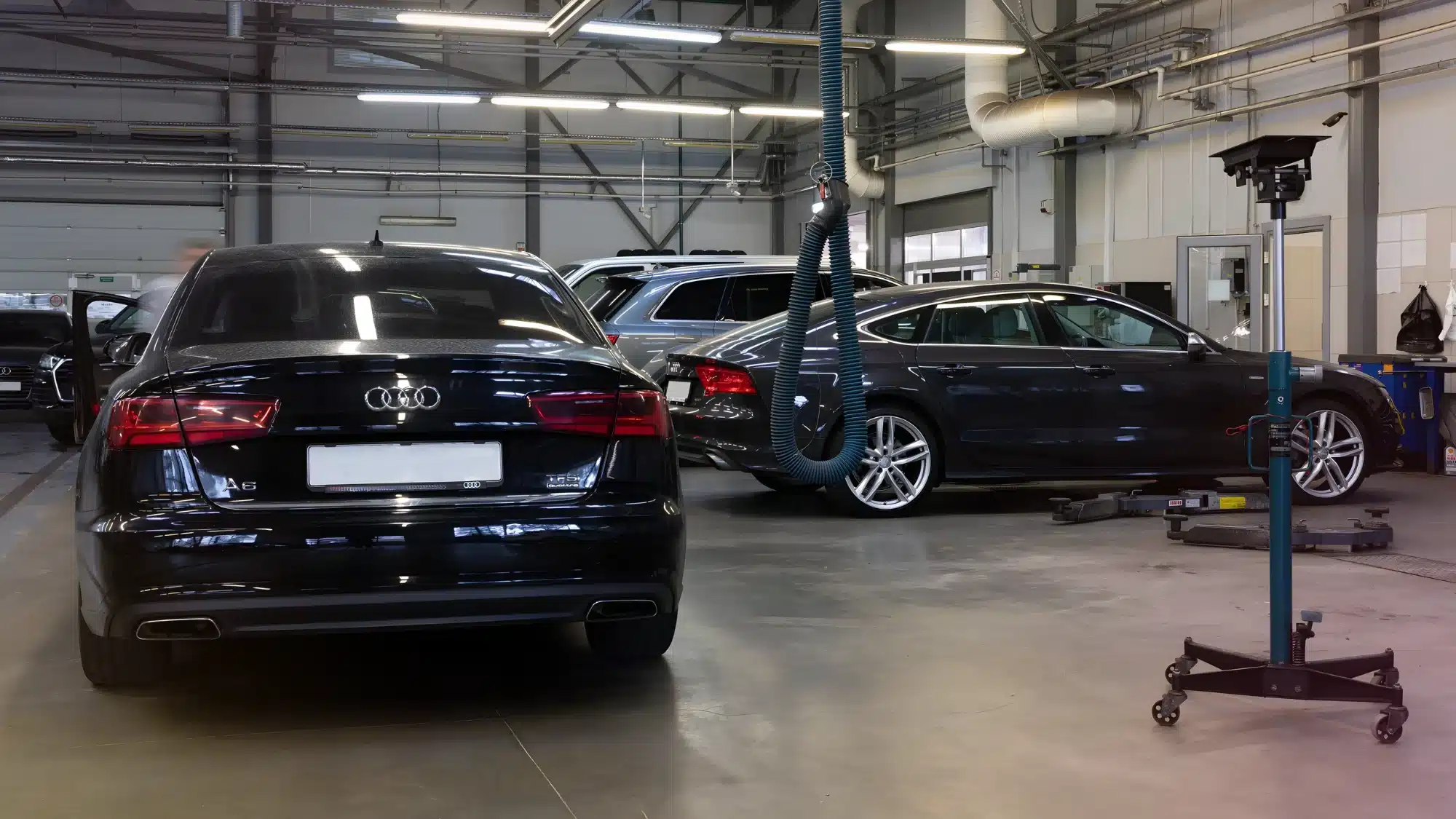 audi auto shop technician performing maintenance and diagnostics on a vehicle