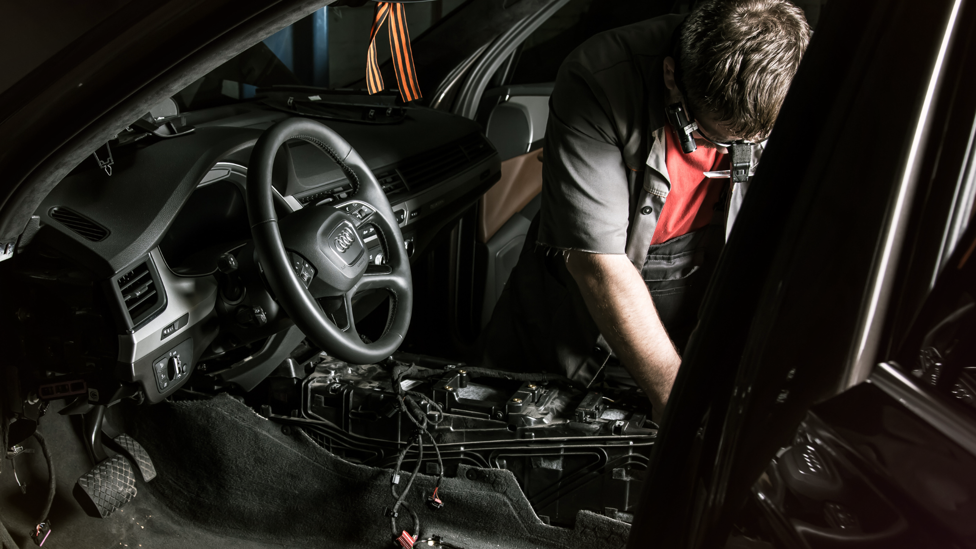 Audi technician performing electrical repair with diagnostic tools